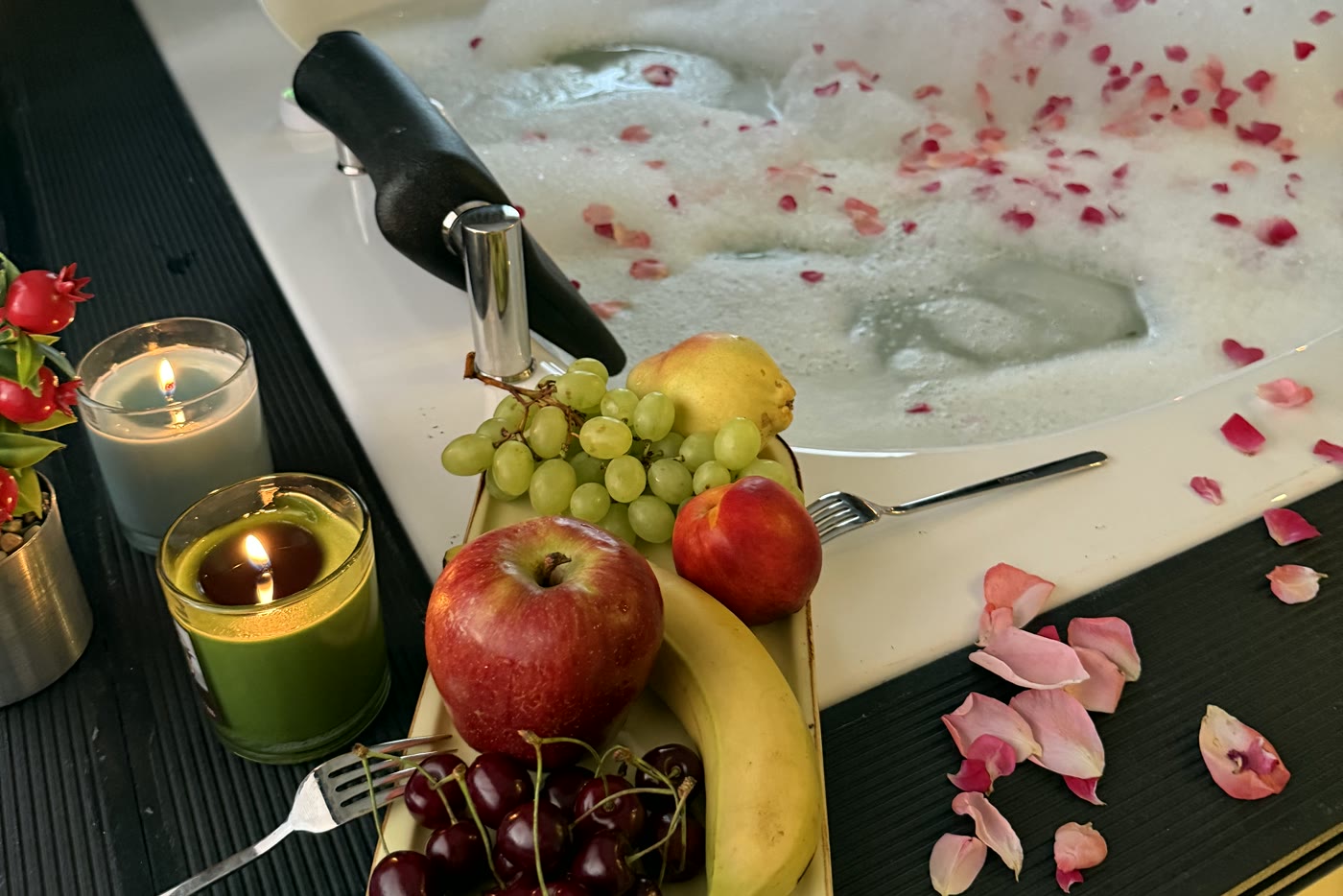 Vorbereitung für besondere Anlässe in der Jacuzzi-Suite: Obst, Kerzen und Rosenblätter